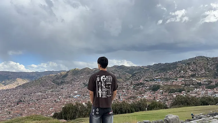 Hugo de espaldas mirando Cusco desde Sacsayhuamán